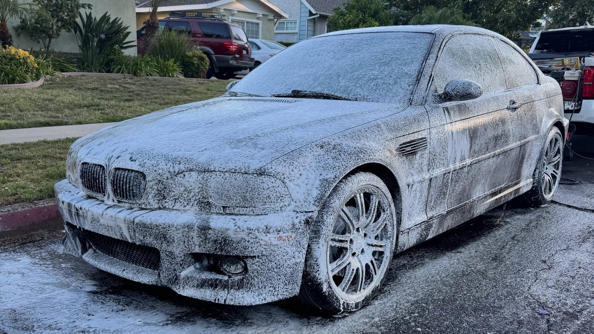A black BMW M3 under foam before the wash